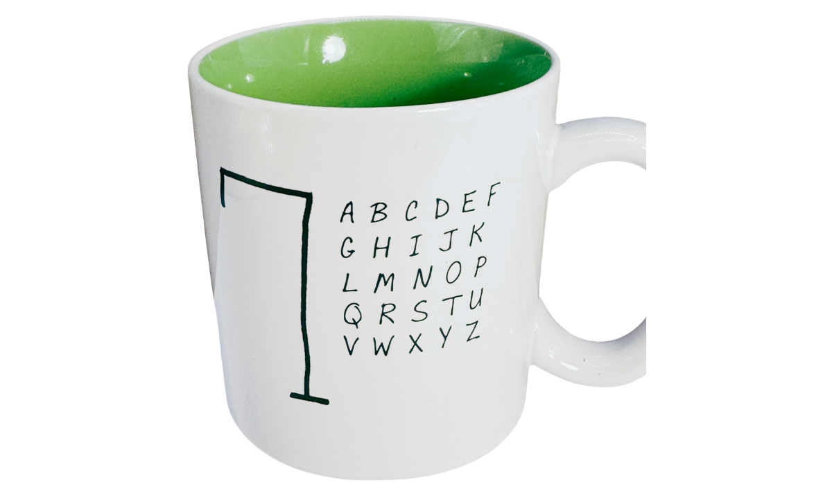 Hangman Game Coffee Mug front view featuring black gallows and alphabet artwork, bright green interior, and curved white ceramic handle.
