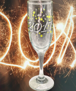 2017 Souvenir Champagne Flute With Stars displayed in front of glowing 2017 numerals formed with golden sparkler trails.