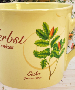 Herbst Ist Landzeit tea mug styled with dried flowers, herbs, and an autumn botanical setting