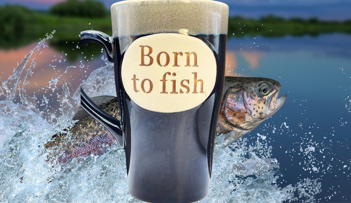 Born To Fish Latte Mug displayed with leaping fish and lake backdrop