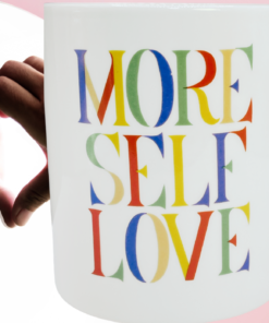 More Self Love Mug displayed beside a person forming a heart with their hands in a mirror