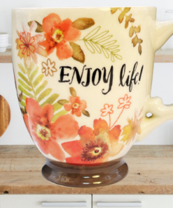 Cracker Barrel Enjoy Life Mug in kitchen scene with coral floral artwork, inspirational wording, and brown footed base