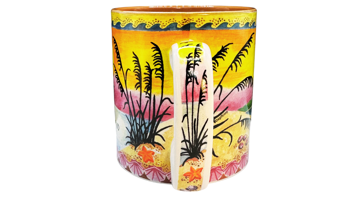 Handle view of Marco Island Florida souvenir mug featuring wraparound beach artwork with sea oats, starfish, and tropical shoreline details continuing behind the handle.