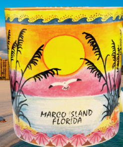 Marco Island Florida souvenir mug displayed against a beautiful Marco Island beach, highlighting its colorful wraparound tropical sunset design.