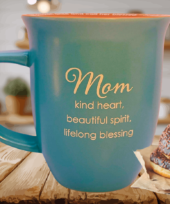 Abbey Gift Mom blessing teal mug on wooden table with chocolate donuts in cozy kitchen setting