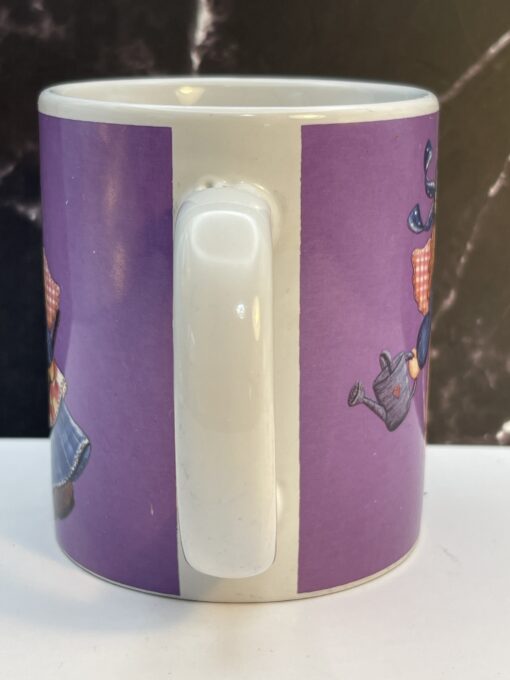 Add heavenly grace and garden magic to your mornings with the Purple Mindy Cain Garden Angel Mug. It's the perfect #cupofmood and serenity in every sip.