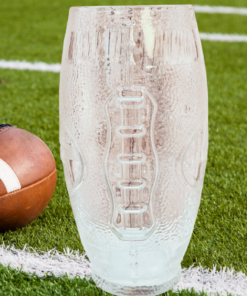 Coors Light Embossed Football Glass displayed on football field beside football