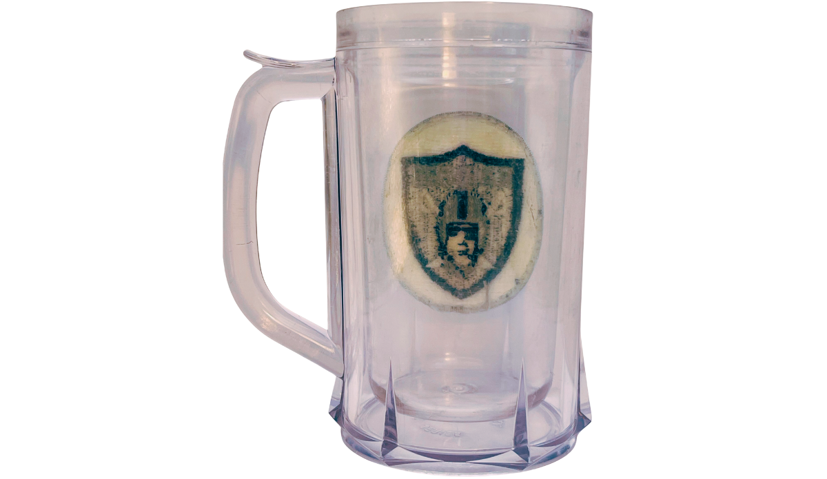 Back view of vintage Los Angeles Raiders acrylic freezer beer mug with shield patch visible through clear body