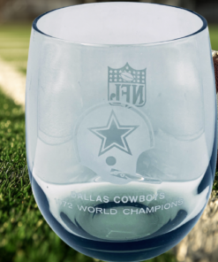 Vintage Dallas Cowboys 1972 World Champions whiskey glass displayed with football on field