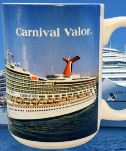 Carnival Valor Cruise Ship Souvenir Mug displayed in front of the Carnival Valor cruise ship at sea