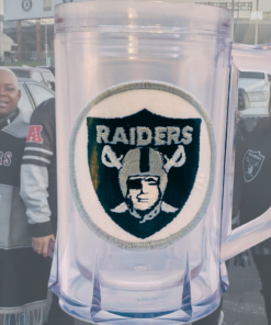 Vintage Los Angeles Raiders acrylic freezer beer mug displayed with Raiders fans in football stadium setting