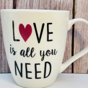 Sip your favorite drink in style with the 14oz Love Is All You Need Mug by Pflatzgraff. Dishwasher safe, microwave safe, and perfect as a gift or personal treat!