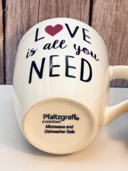 White ceramic Love Is All You Need Mug with pink heart