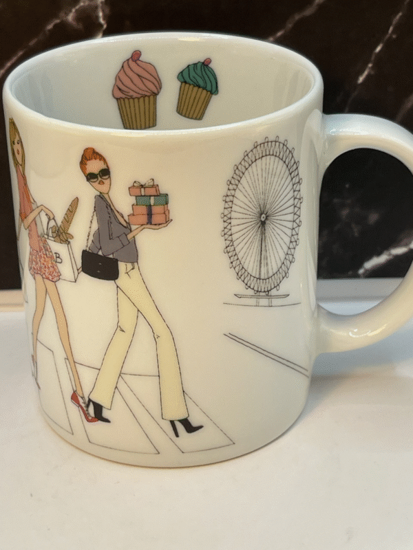  Charming white porcelain coffee mug features whimsical illustrations of women.