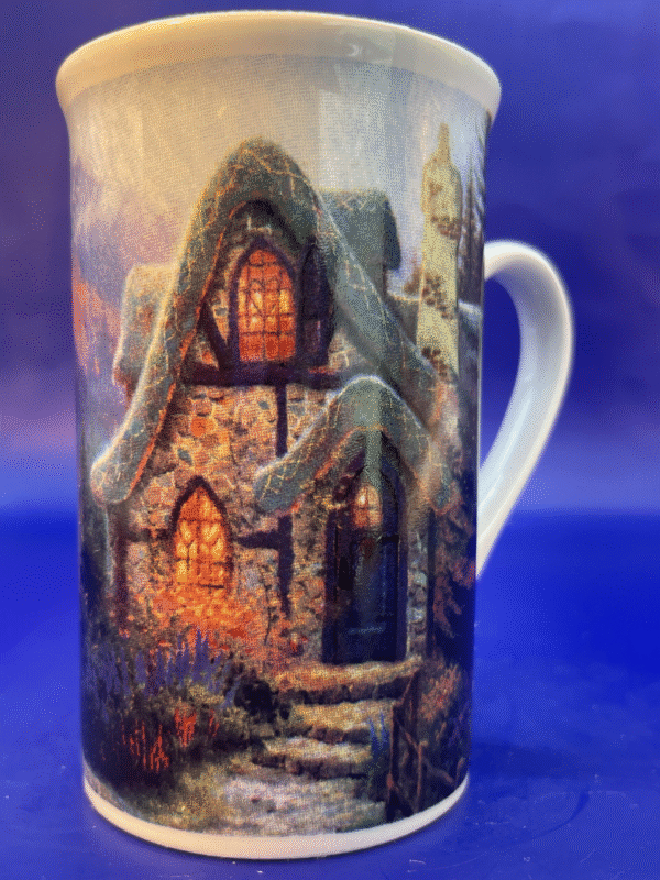 This 14-ounce white ceramic mug features the idyllic painting of a cozy cabin. It’s illuminated from within, surrounded by the vibrant colors of fall.