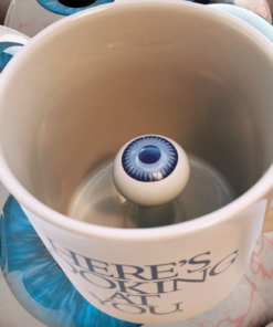 3D Eyeball Mug displayed among oversized blue eyeballs with its hidden interior eye clearly visible.
