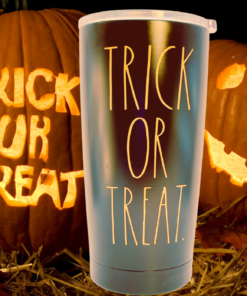 Rae Dunn Trick or Treat Tumbler displayed with glowing jack-o’-lanterns, straw, and autumn leaves