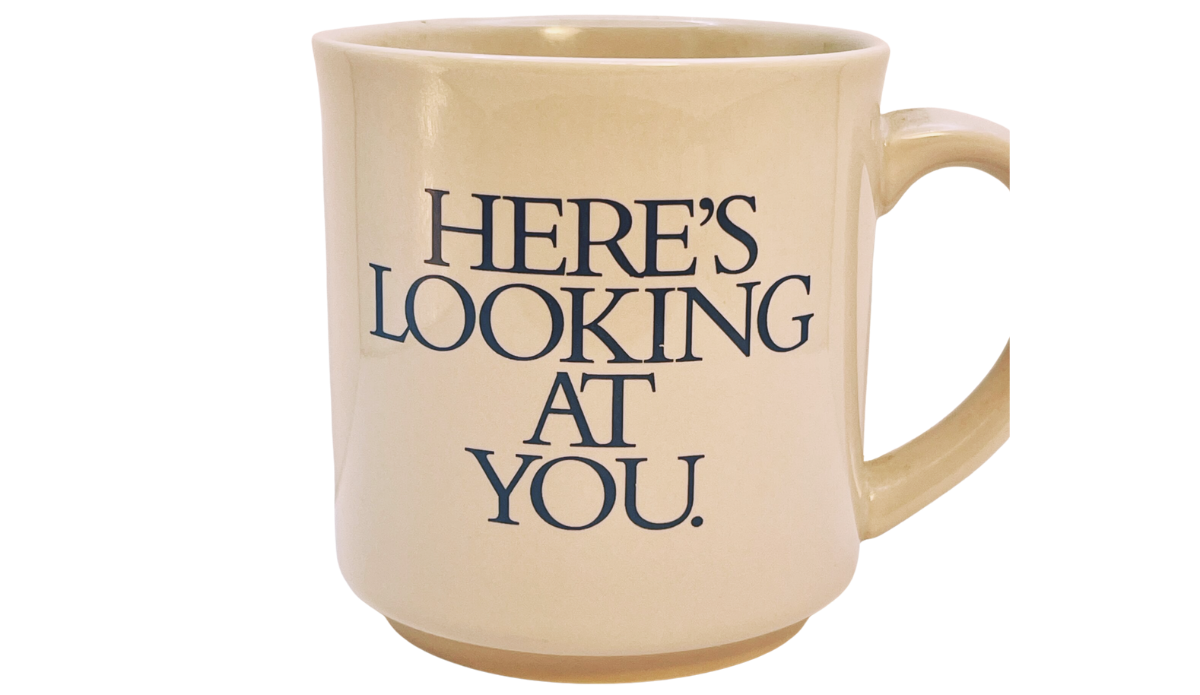 3D Eyeball Mug front view with Here’s Looking At You message in dark blue lettering on warm cream ceramic.