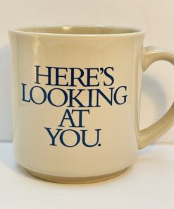 Light gray Here’s Looking At You Mug with blue lettering on the outside