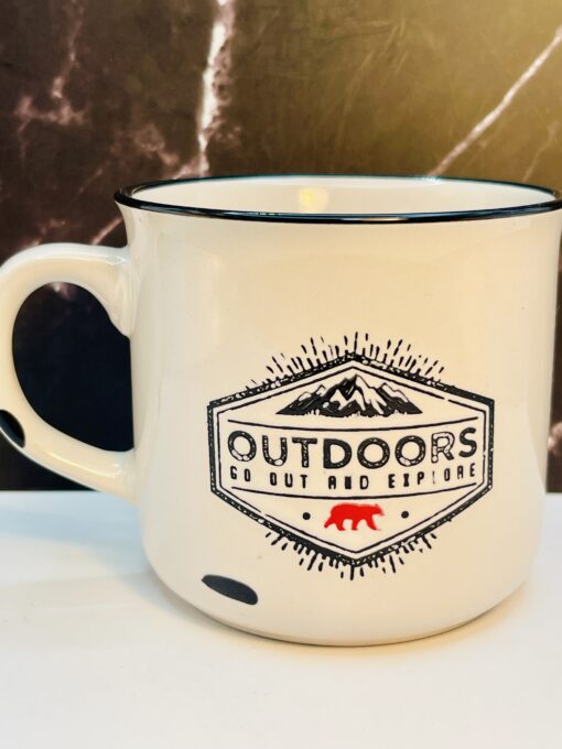 White enamel mug with crossed axes and tree design
