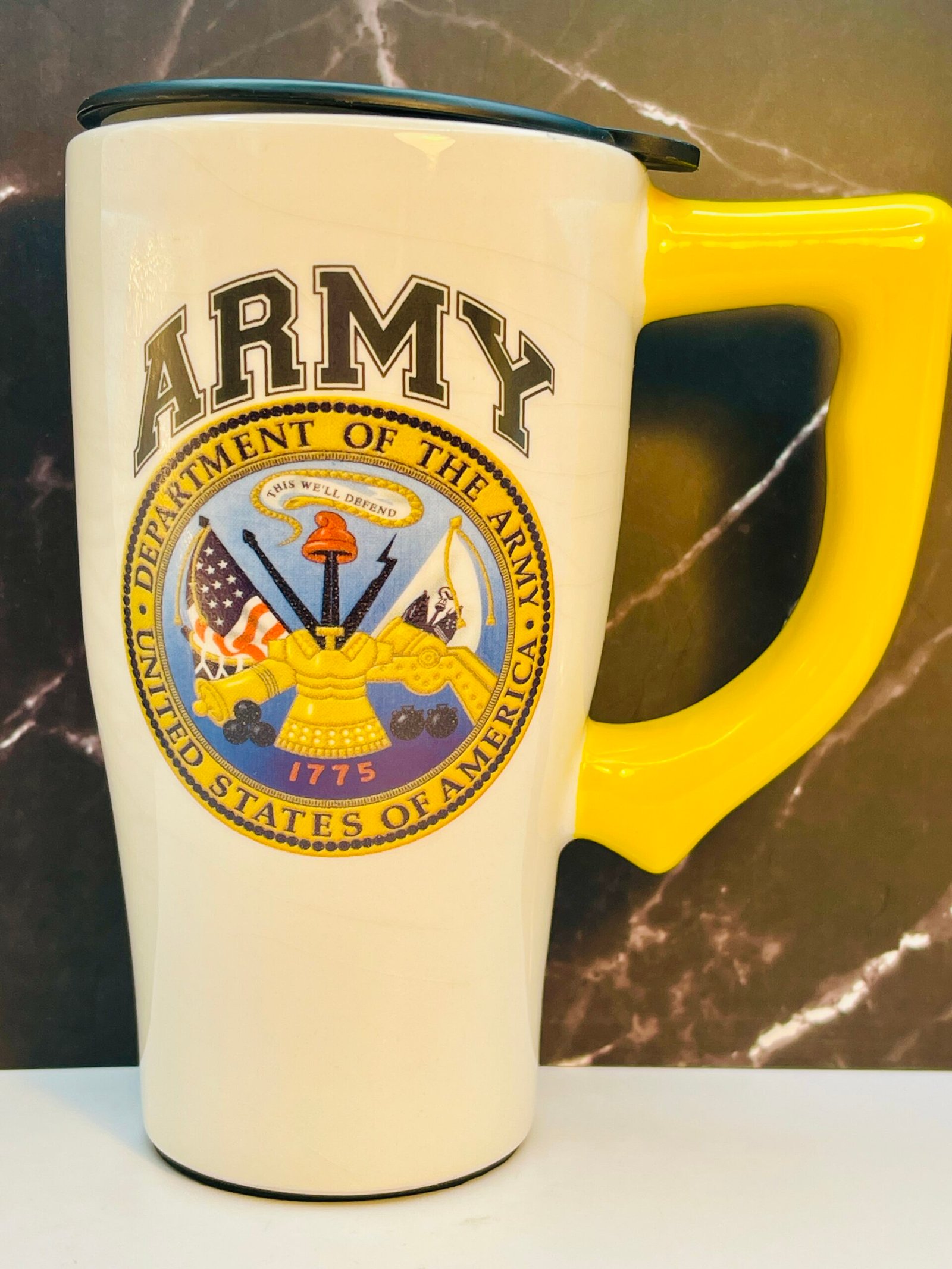 U.S. Army ceramic travel mug with yellow handle and black lid.