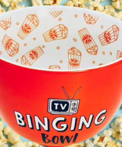TV Binging Bowl displayed among freshly popped popcorn with red-orange exterior and patterned white interior