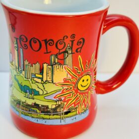 Georgia souvenir mug with cartoon skyline and sun design