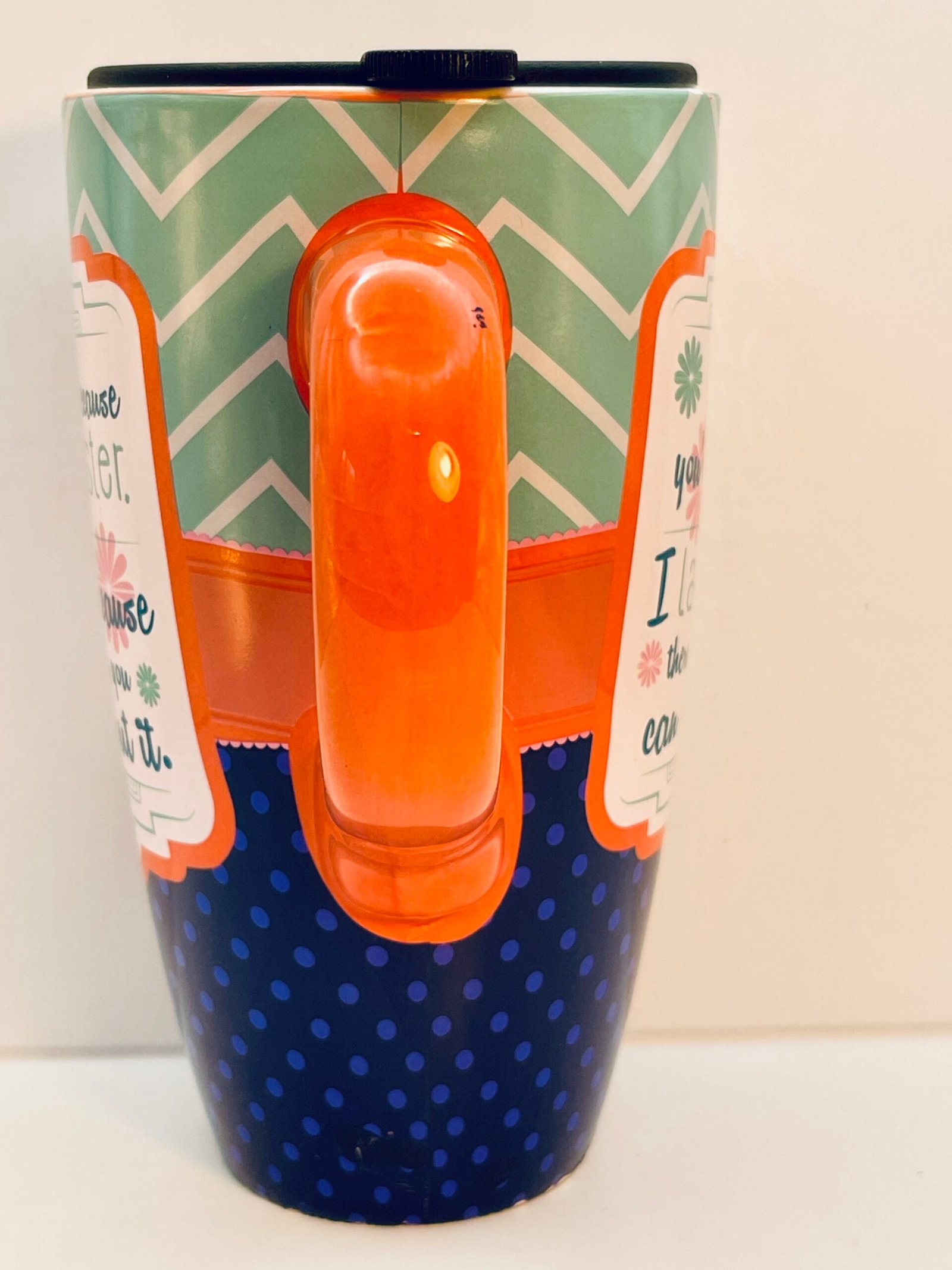 Ceramic travel mug with ergonomic orange handle and black lid