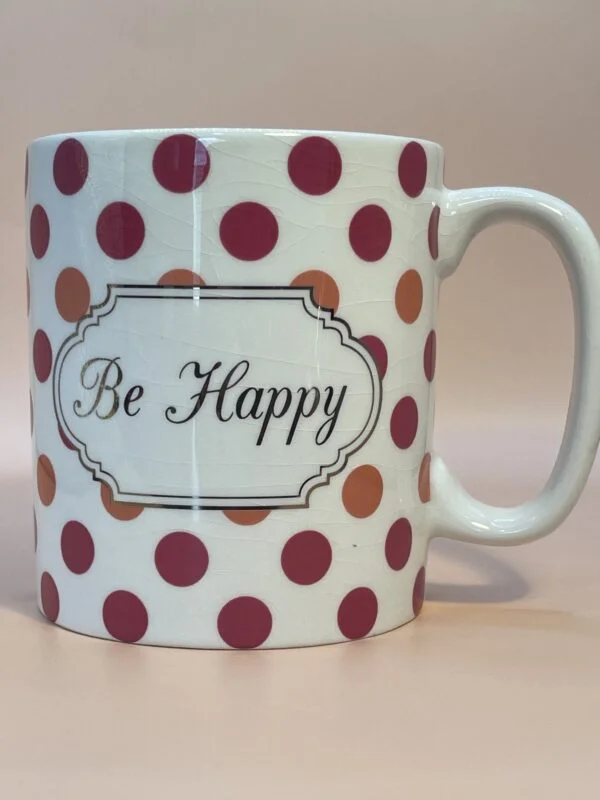 White ceramic mug with polka dots and the words, Be Happy, in the  middle. 