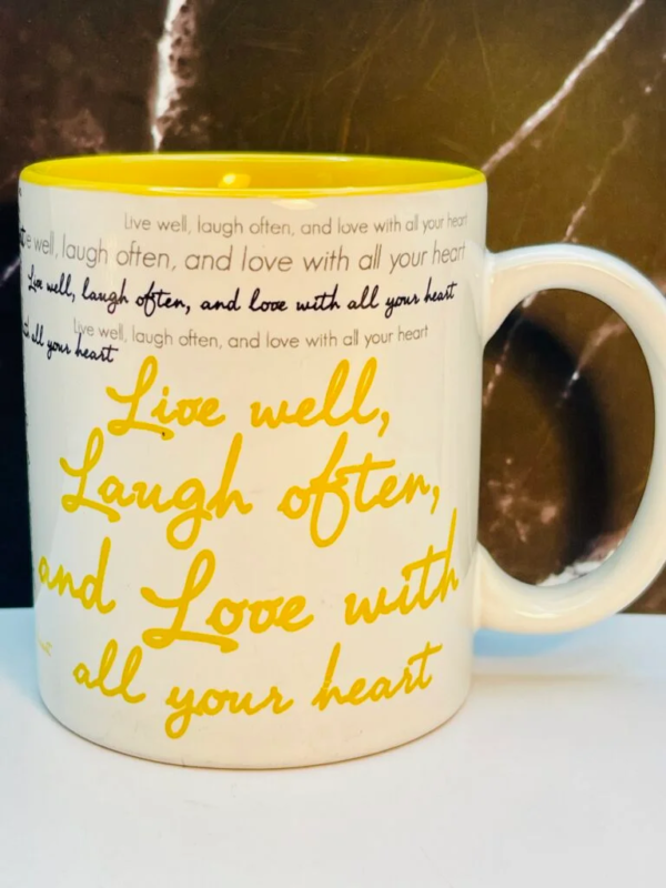 Start your mornings with a smile and a sip with this 12 ounce white ceramic Live Well Laugh Often Love Mug.