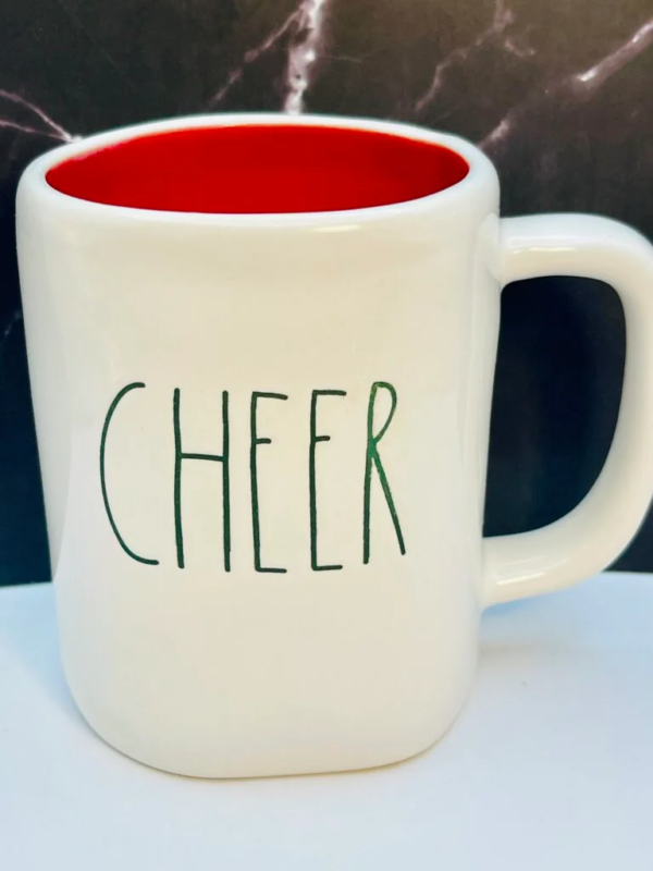 This 14 ounce white ceramic Rae Dunn Cheer Red Inside Mug has a red inside and the word, Cheer in green embossed letters on the front.  