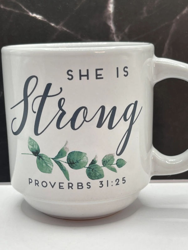 This elegant 12-ounce white ceramic She's Strong Proverbs 31:25 Mug features the uplifting phrase “She Is Strong” . They’re in bold black letters on both sides.