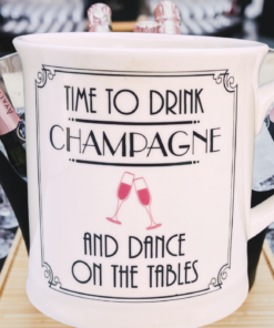 Champagne and Dance Mug displayed at a celebration with champagne bottles, ice buckets, and rows of empty champagne flutes.