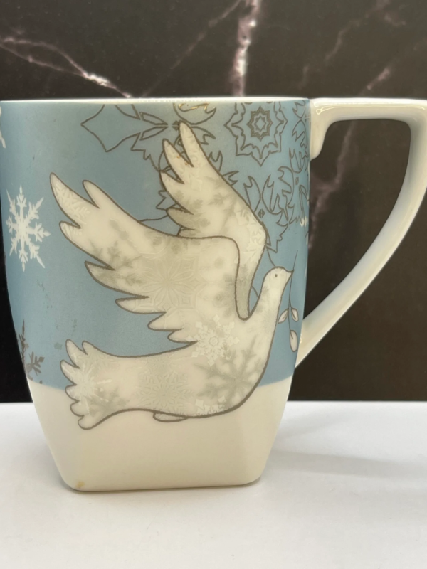 This exquisite 20-ounce white ceramic mug features a peaceful white snow dove. It’s delicately perched against a stunning sky-blue background.