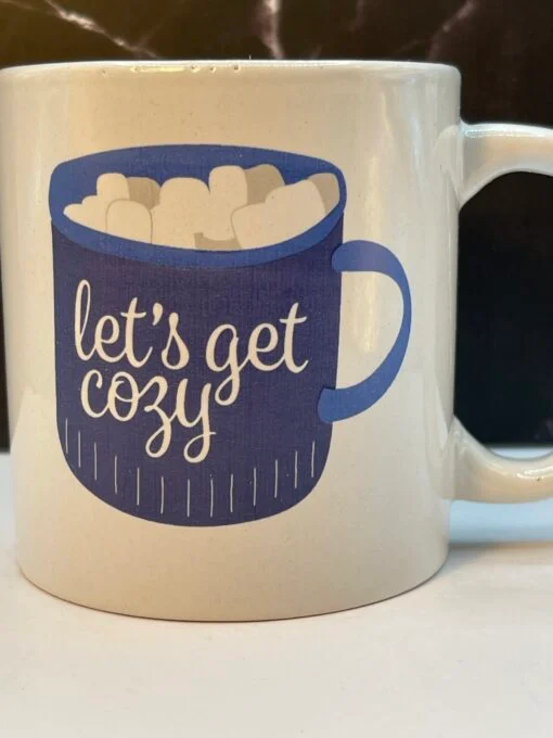 This 14-ounce white ceramic mug is designed to make every sip feel like a warm hug. On both sides of the mug, you’ll find an adorable blue coffee cup brimming with marshmallows. Setting the mood for a snug and relaxed vibe.