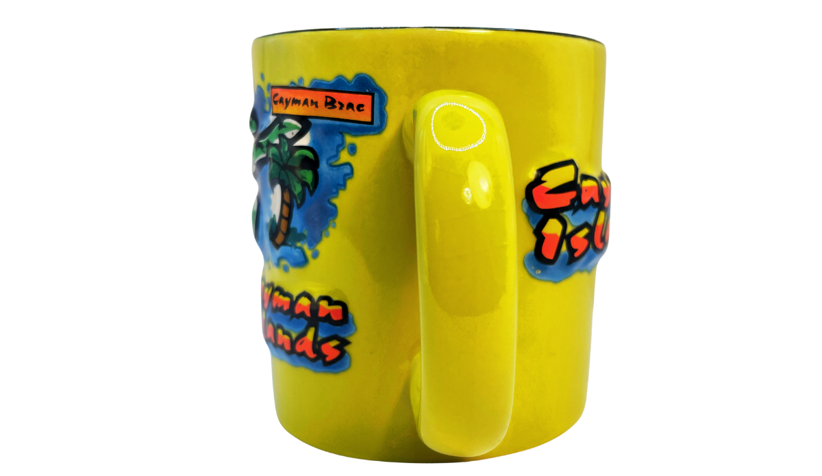 Front view of a Cayman Islands souvenir mug showcasing a raised 3D map of Grand Cayman, Little Cayman, and Cayman Brac with tropical details.