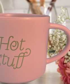 pink hot stuff mug styled in cozy pink setting with flowers and soft lighting