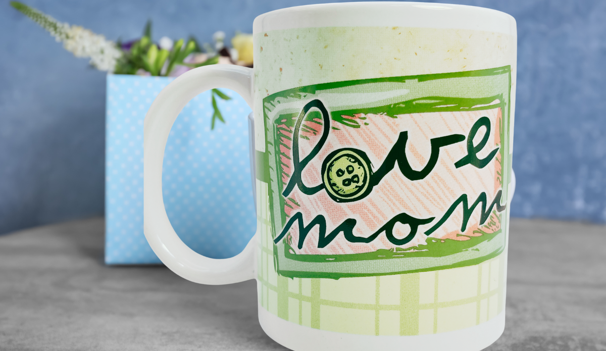 I love you mom floral plaid mug styled with blue gift bag and flowers in background