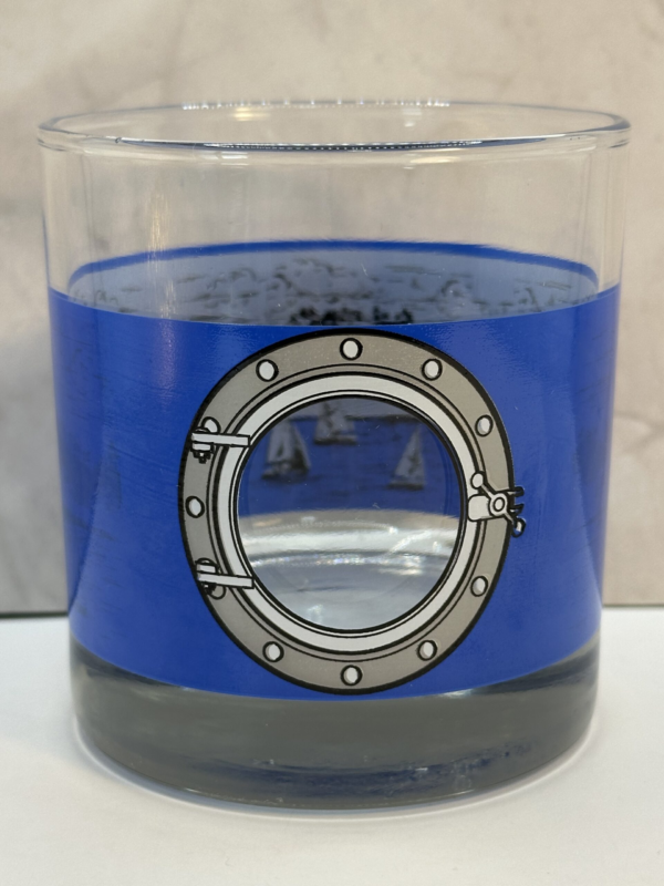 Sip and savor the spirit of adventure with the Royal Caribbean Souvenir Whiskey Glass. It’s the perfect #cupofmood and the crown jewel to your Cruise Collection and Travel Souvenir Cup Collection.
Indeed this stunning 10-ounce clear whiskey glass is not just a drinking vessel. It’s also a portal to the serene beauty of the open seas.
In fact, the Royal Caribbean Souvenir Whiskey Glass features a striking porthole design etched into a vibrant blue background on the outside of the glass.