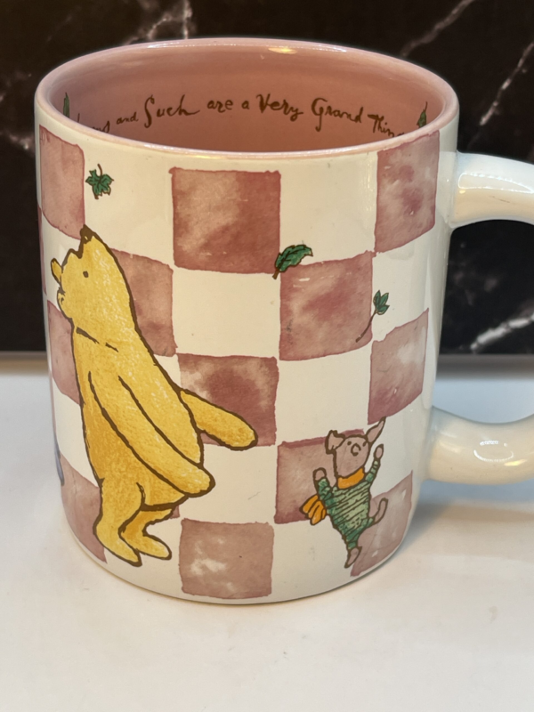 Introducing the Hums Such Winnie Pooh Mug from the CupofMood Shop. It’s the perfect #cupofmood for those who love a gentle morning with a bit of Winnie the Pooh charm.

Indeed, this 14-ounce white ceramic mug features an adorable pink and white checkerboard pattern. It’s brought to life by the lovable Winnie the Pooh characters who grace the front.