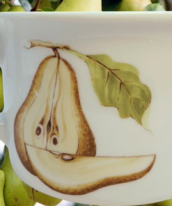 Vintage Seymour Mann San Fernando pear mug displayed among fresh pears in orchard setting