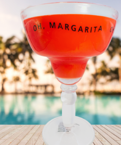 red acrylic margarita glass poolside scene with tropical background