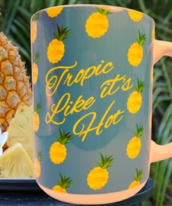 Rainforest Cafe Tropic Like It's Hot Pineapple Mug displayed in tropical island setting