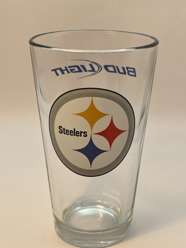 This Pittsburgh Steelers Drinking Glass with Bud Light is the perfect #cupofmood to celebrate your love for the Pittsburgh Steelers and Bud Light.This vintage NFL Drinking glass is a true collector’s gem that pays homage to the pride of Pittsburgh Steelers Fandom.Crafted with nostalgic charm, this Pittsburgh Steelers Drinking Glass with Bud Light features the iconic Pittsburgh Steelers Logo. While on the back is the Bud Light logo.