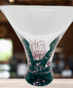 Vintage Amethyst Splatter Cocktail Glass displayed on a bar with colorful cocktail ingredients in the background
