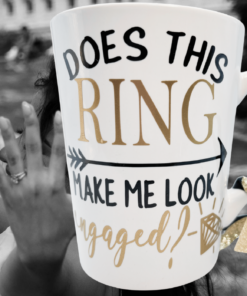 Does This Ring Make Me Look Engaged Ribbon Mug displayed with engagement ring and romantic setting