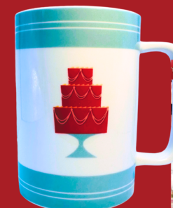 Cake Boss Turquoise Mini Cakes Porcelain Mug styled in a bakery inspired kitchen with coffee and desserts