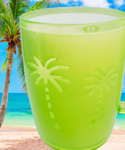 Neon green acrylic tumbler with embossed palm trees displayed on a tropical beach