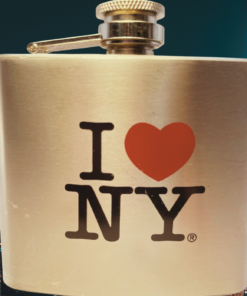 I Love NY Silver Stainless Steel Hip Flask displayed against a glowing New York City nighttime skyline