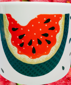 Vintage Tabletops Unlimited Fresh Watermelon Oversized Coffee Mug displayed with fresh watermelon slices in a bright summer setting.
